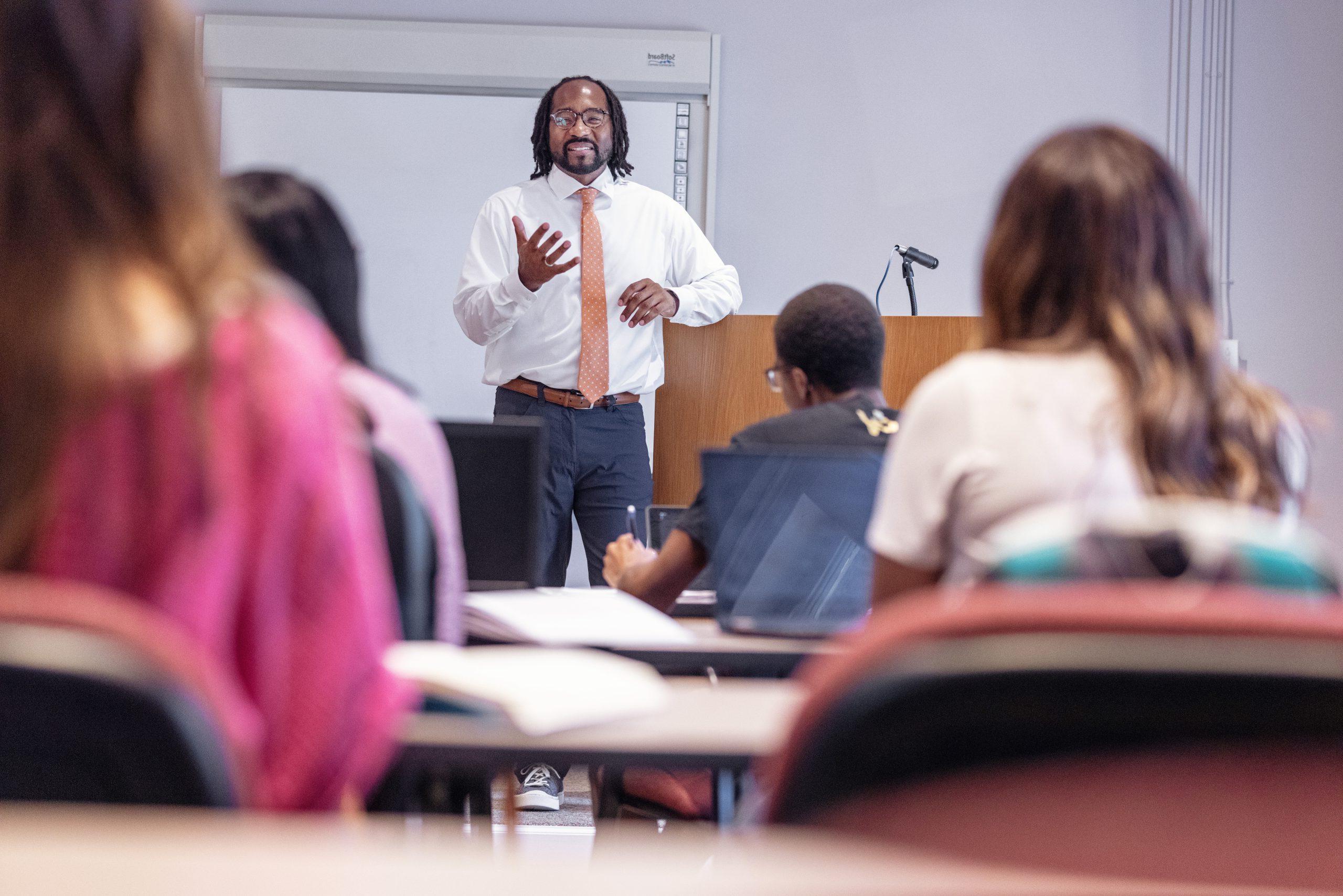 A University of Montevallo professor smiles during a lecture inside a classroom in Wills Hall.